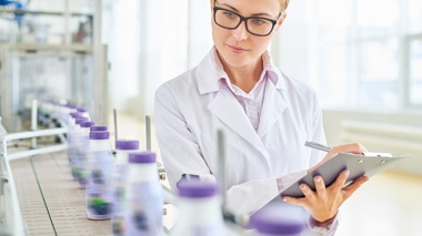 Woman with a clipboard reviewing a production line