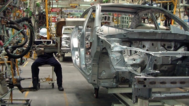 Worker in a car frame manufacturing warehouse