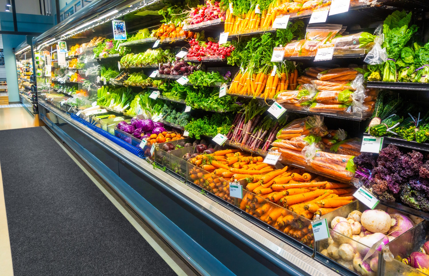a wall of produce at the grocery store